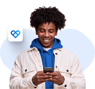 Imagem de um homem, sorrindo, mexendo no aplicativo Vale Saúde de frente para a câmera